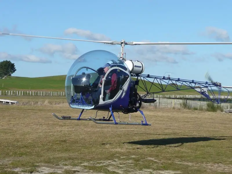 Blue and white Safari 400 helicopter parked on grass