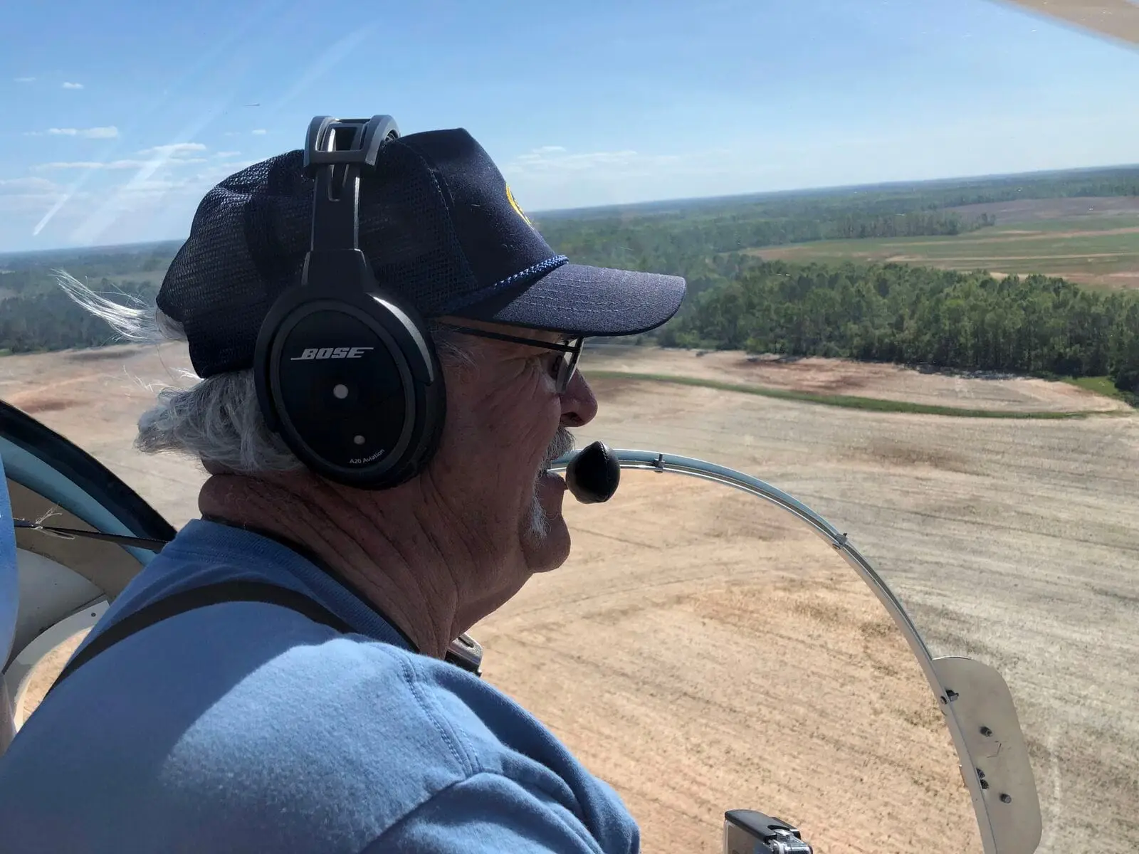Pilot wearing a headset at the controls of a Safari helicopter, point of view from the cockpit