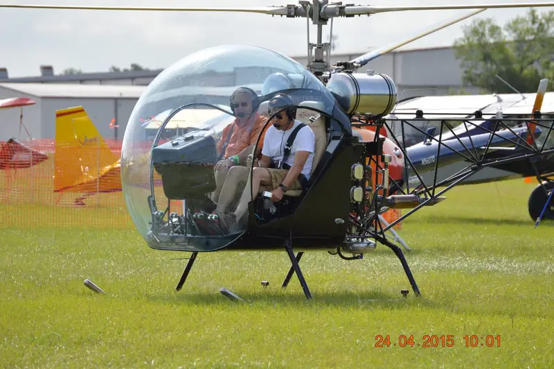 Safari 400 helicopter with two people aboard at a fly-in