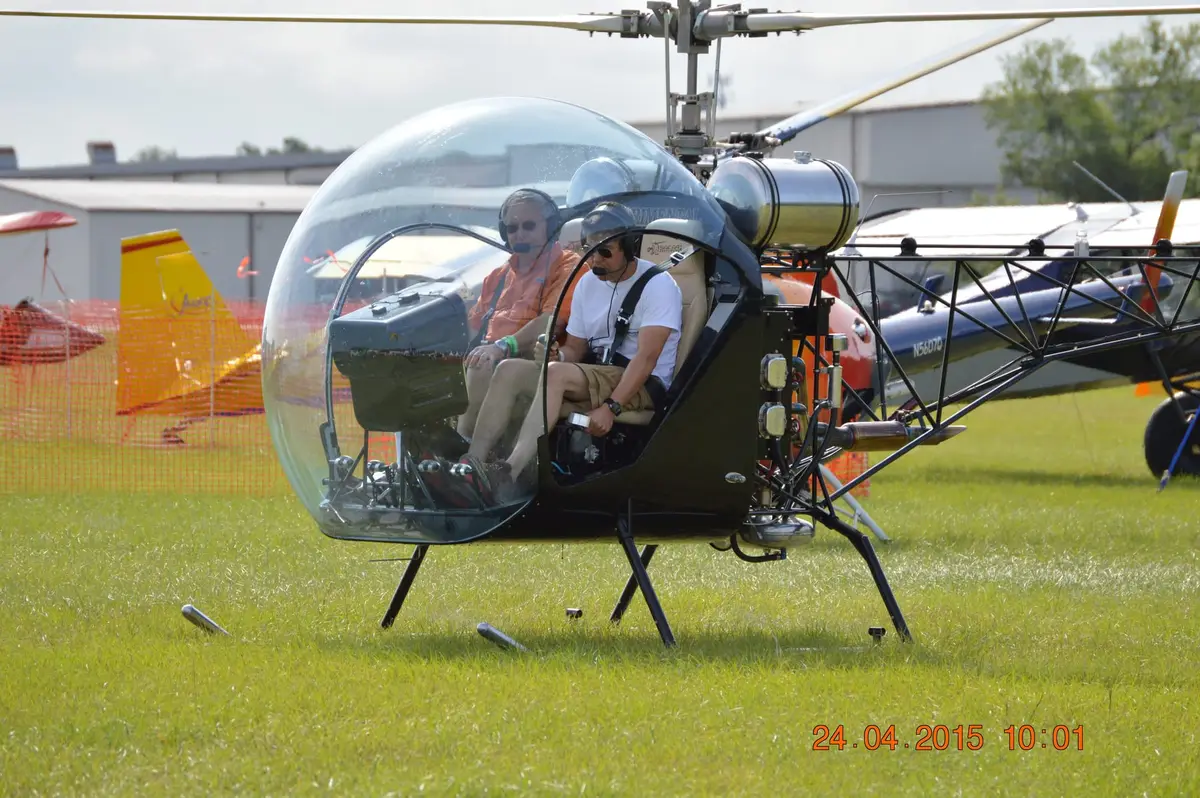 Safari 400 helicopter with two people aboard at a fly-in