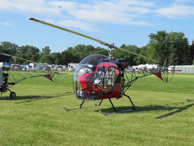 Red Safari 400 helicopter parked on grass