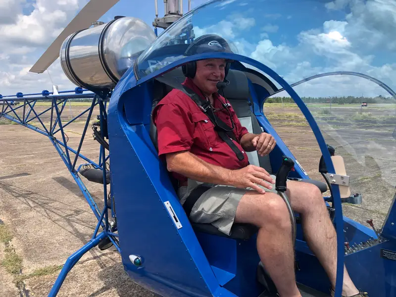 Pilot seated in the cockpit of a blue Safari 400 helicopter