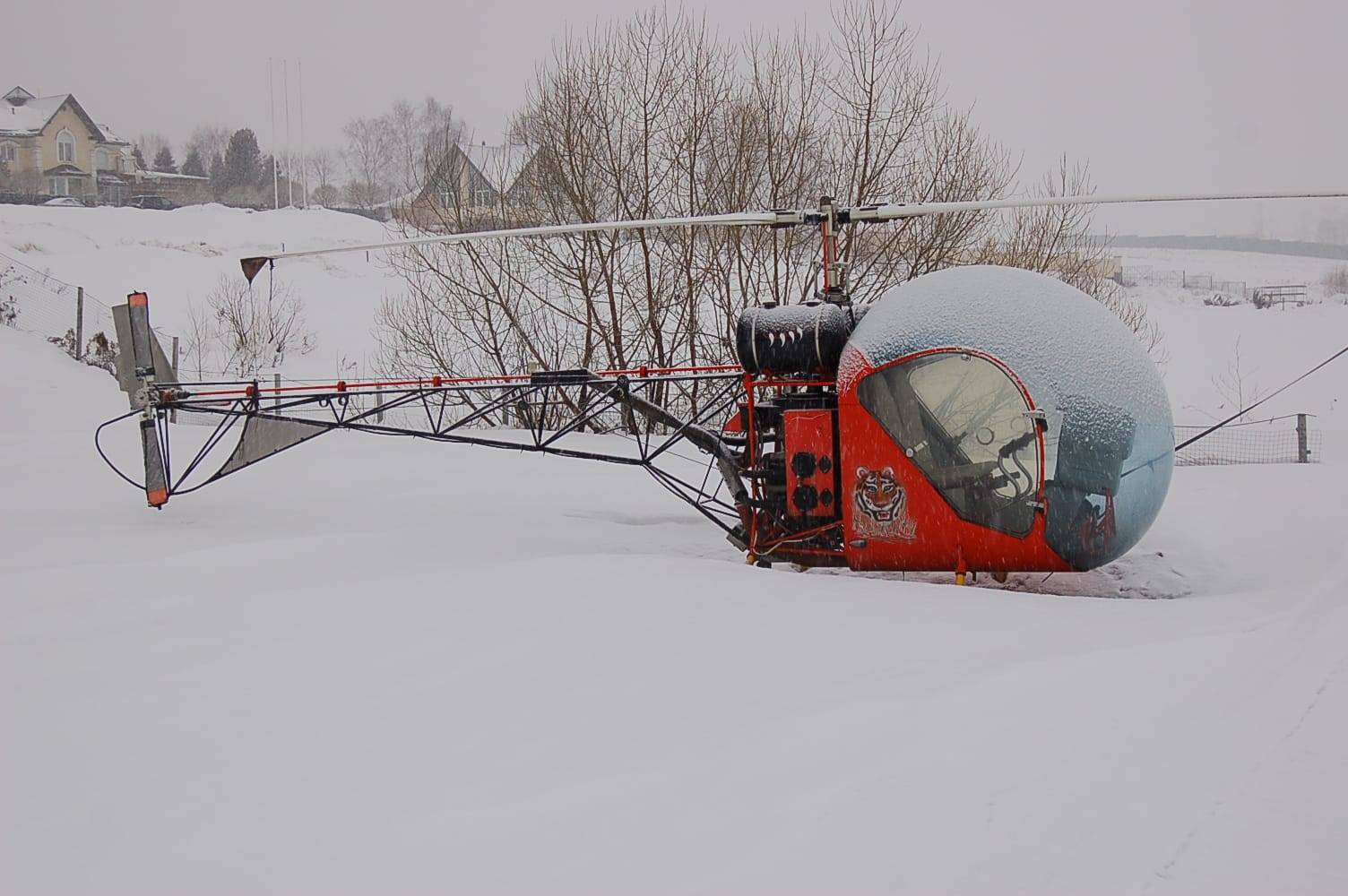 Red Safari 400 helicopter on snow-covered ground in Russia