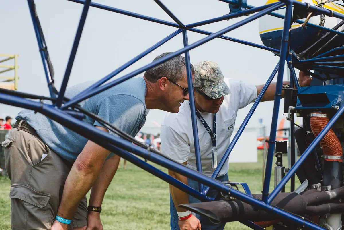Builders working on a Safari helicopter frame at an event
