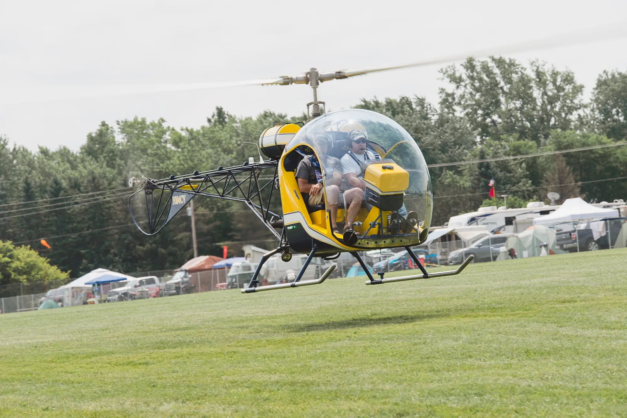 Yellow Safari 400 helicopter lifting off the grass at EAA AirVenture Oshkosh