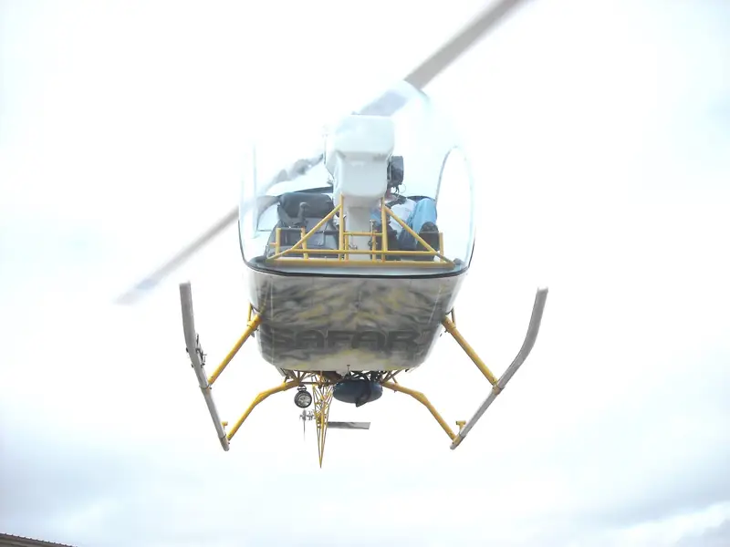 Safari 400 helicopter hovering against a white sky, seen from below and in front
